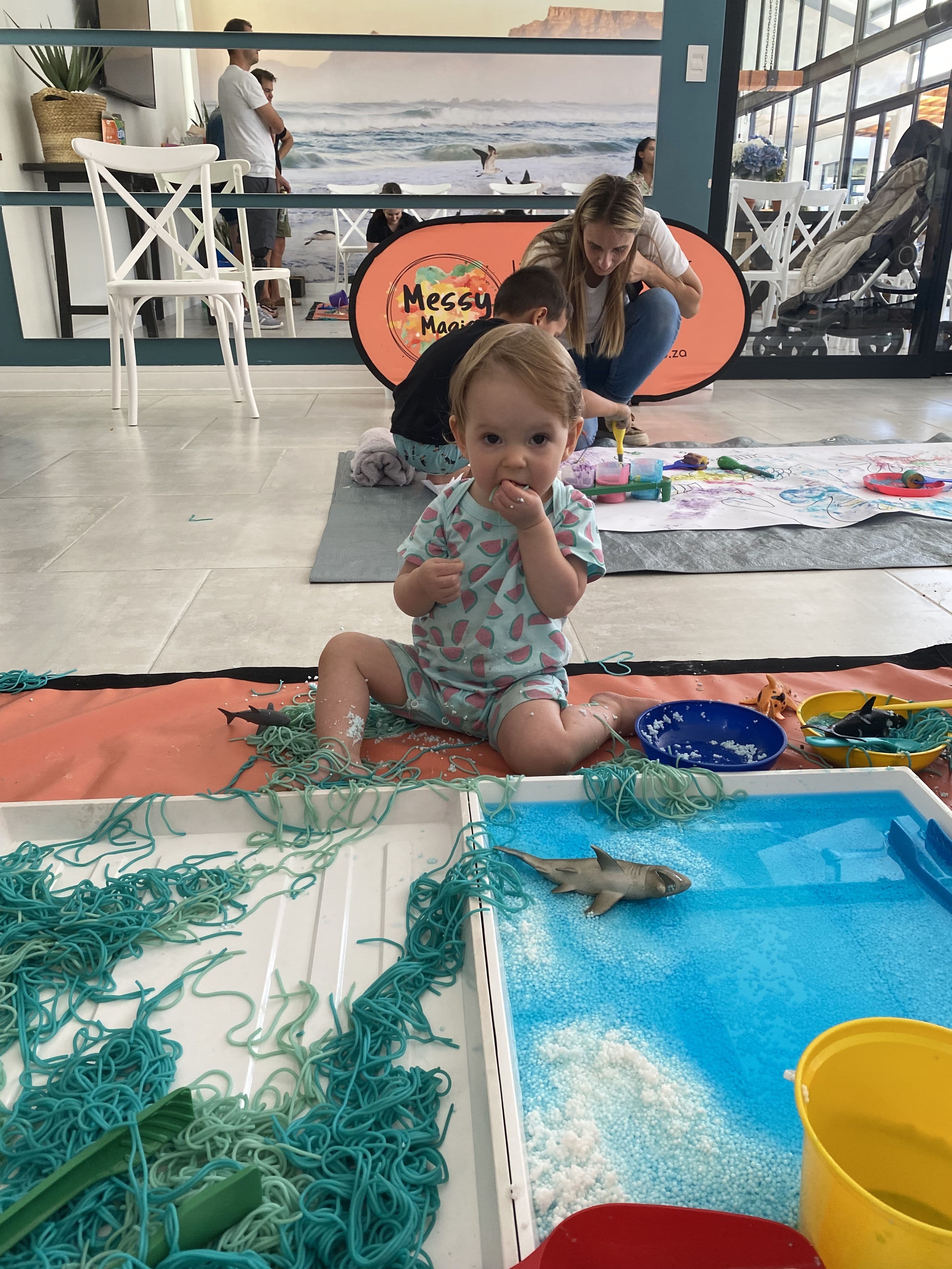 A girl playing with coloured spaghetti at an Under the Sea themed party hosted by Messy Magic